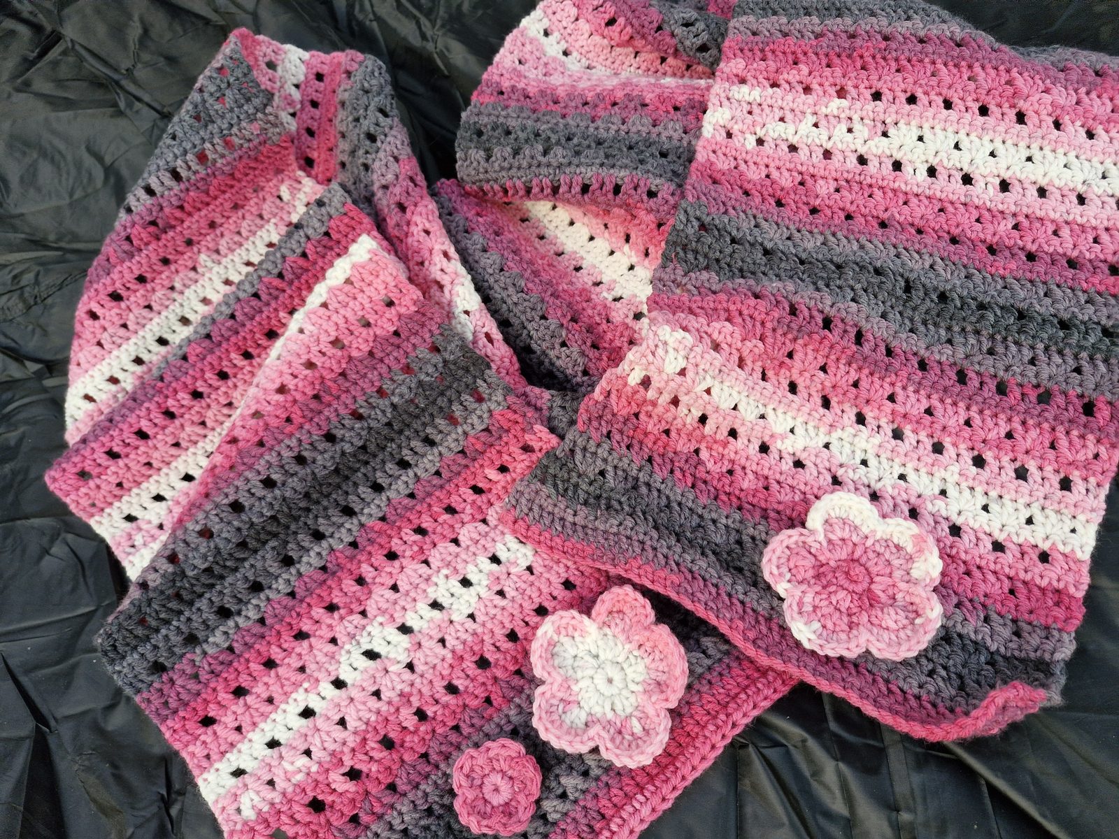 Finished chunky crochet shawl with color-changing stripes and flowers